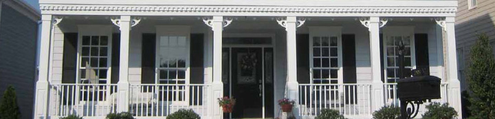 Front suburban house with white trim around windows and white columns