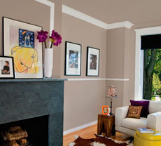 A living room with a light brown walls and white baseboards, chair rails and crowns.