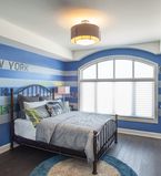 Blue and white strip painted bedroom with white baseboards and white casing around the large window