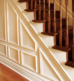 Oak staircase with white moulding and paneling on the side