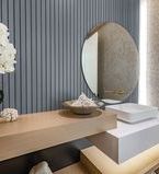 Blue grey slatwall treatment in bathroom with round mirror