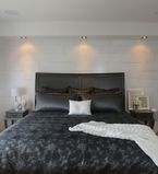 Chambre à coucher présentant un mur recouvert de moulures à feuillure blanches