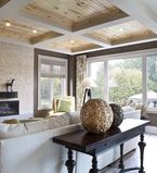 Living room with white casing around windows and wooden wainscot on the ceiling 